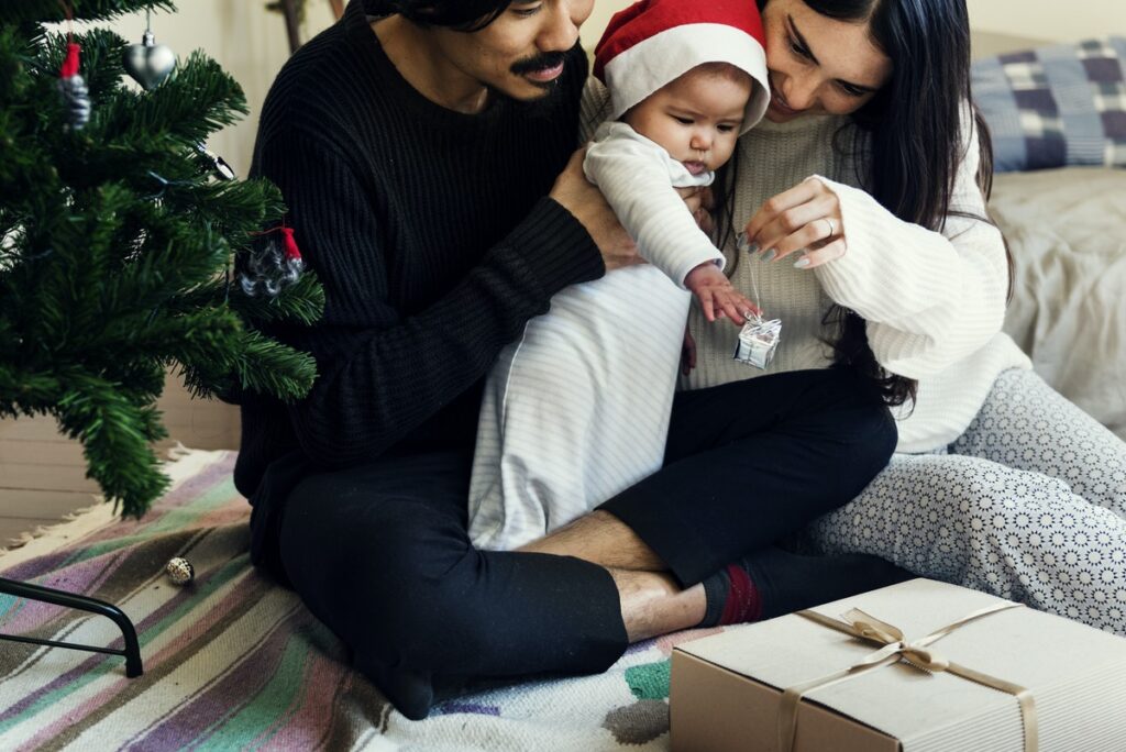 baby with parents opening presents at christmas